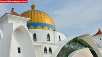 Melihat masjid ini dari seberang pantai adalah salah satu spot terbaik. Yang melihatnya akan terbuai dengan keindahan arsitektur gabungan gaya melayu dan timur tengah. Kubah yang berwarna kuning dikombinasikan dengan dinding masjid yang berwarna putih. Bukan cuma menghadap ke lautan, dekorasi kaca setengah lingkaran dibuat megah di atas pintu masjid, mempercantik tampilan rumah ibadah tersebut.  Istimewa/Dok. www.beautifulmosque.com.