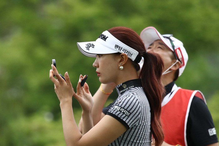 Meski tampil di luar ruangan dan di bawah terik menteri, pegolf Yoo Hyun-Ju tetap memperhatikan penampilan. Ia tampak bermake up sebelum beraksi di KLPGA Championship.