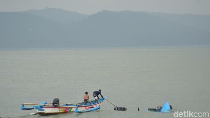 Nelayan berusaha mengevakuasi perahunya yang karam akibat badai yang melanda pantai timur Pangandaran.
