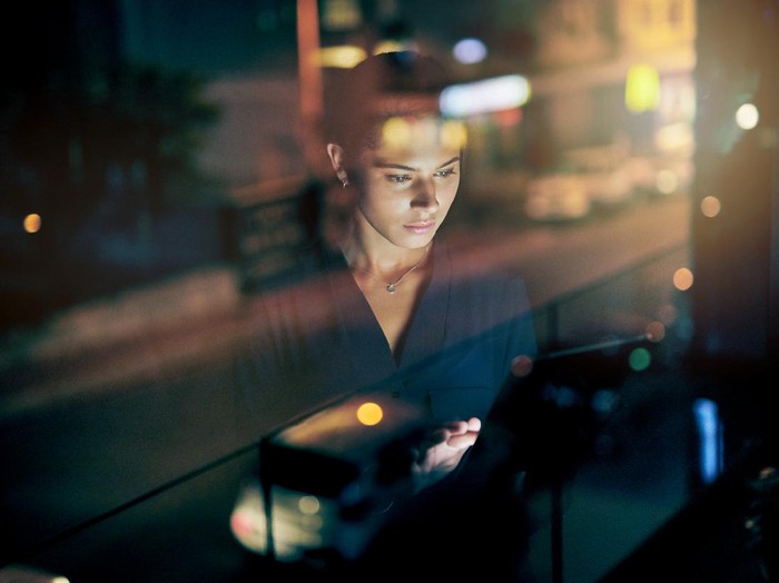 lembur wfh Shot of a young businesswoman using a digital tablet during a late night in a modern office