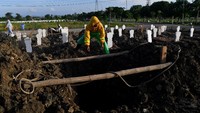 Petugas menyiapkan liang lahat untuk jenazah kasus COVID-19 di Tempat Pemakaman Umum (TPU) Keputih, Surabaya, Jawa Timur, Sabtu (16/5/2020).