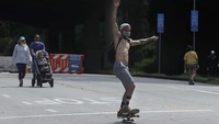 Seorang pemuda tampak bermain skateboard di jalanan ibu kota. Suasana di California ini diambil pada 17 Mei 2020 kemarin. Foto: AP/Jeff Chiu