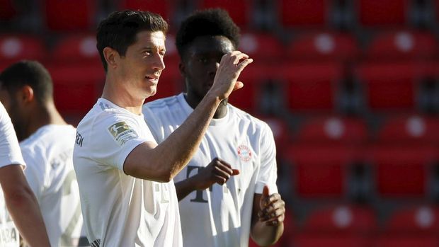 Robert Lewandowski of Munich celebrates his side's opening goal during the German Bundesliga soccer match between Union Berlin and Bayern Munich in Berlin, Germany, Sunday, May 17, 2020. The German Bundesliga becomes the world's first major soccer league to resume after a two-month suspension because of the coronavirus pandemic. (AP Photo/Hannibal Hanschke, Pool)