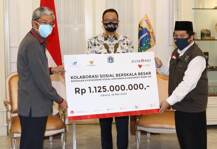 Bantuan Kemanusiaan untuk Lawan COVID-19 Gubernur Provinsi DKI Jakarta, Anies Baswedan bersama Direktur Utama Bank DKI, Zainuddin Mappa (kiri) dan Ketua Baznas (Bazis) DKI Jakarta, Ahmad Lutfi Fathullah (kanan) berfoto bersama usai melakukan penyerahan bantuan kemanusiaan oleh Bank DKI senilai total Rp 5 miliar untuk mendukung penanganan COVID-19 di DKI Jakarta, Senin (18/5).