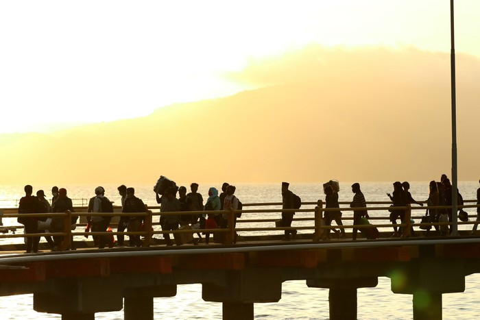 H-6 ARUS MUDIK LEBARAN PELABUHAN KETAPANG-GILIMANUK Petugas kesehatan memeriksa suhu tubuh para pemudik usai turun dari kapal di Pelabuhan Ketapang, Banyuwangi, Jawa Timur, Senin (18/5/2020). Pada H-6 arus mudik Idul Fitri dari Pulau Bali dengan tujuan Pulau Jawa di Pelabuhan Ketapang terpantau ramai penumpang pejalan kaki. ANTARA FOTO/Budi Candra Setya/wsj.
