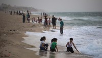 Sementara Anak-anak asyik bermain air di pesisir pantai tersebut saat waktu akhir pekan tiba.