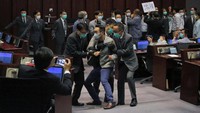 Sejumlah anggota parlemen pro-demokrasi dikeluarkan dari gedung oleh petugas keamanan.