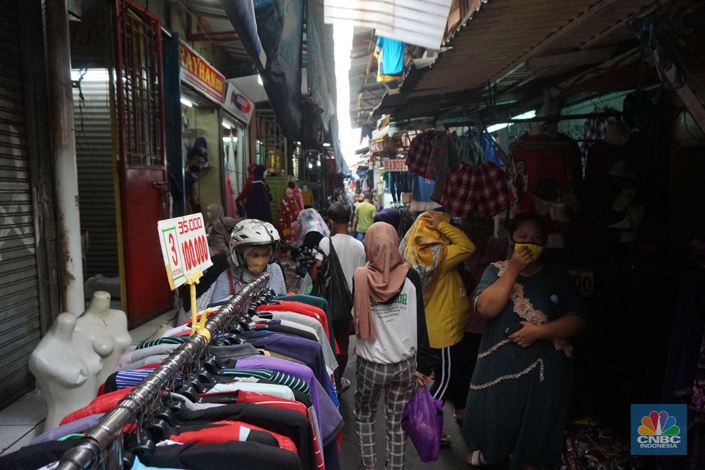 Warga memadati kawasan pedagang kaki lima di Pasar Tanah Abang saat penerapan pembatasan sosial berskala besar (PSBB) di Jakarta, Senin (18/5/2020). Meski pertokoan di Pasar Tanah Abang tutup karena PSBB, menjelang hari lebaran kawasan tersebut dipadati pedagang kaki lima yang berada di gang-gang dekat pasar. վ/Tri Susilo.   Memasuki H-7 lebaran Idul Fitri, Pasar Tanah Abang kembali ramai dipadati masyarakat meskipun pemerintah Provinsi DKI Jakarta masih menutup pasar tersebut sejak 27 Maret karena diberlakukanPembatasan Sosial Bersekala Besar (PSBB) untuk mengatasi penyebaran Covid-19.Keramaian terlihat disejumlah titik seperti sebrang Blok F dan depan stasiun Tanah Abang, jalanan tersebut dipadati pedagang kaki lima dan warga tanpa mematuhi peraturan jaga jarak sesuai dengan himbauan pemerintah.Para pedagang nekat turun kepinggir jalan karena sejak kios mereka ditutup, para pedagang tidak mendapatkan penghasilan, padahal biasanya menjelang lebaran mereka bisa meraup untung besar. (վ/Tri Susilo.)