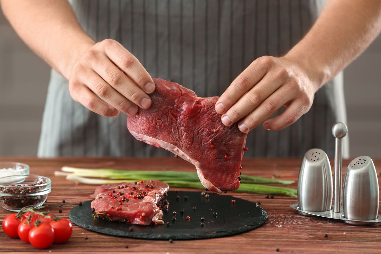 Man preparing meat in kitchen