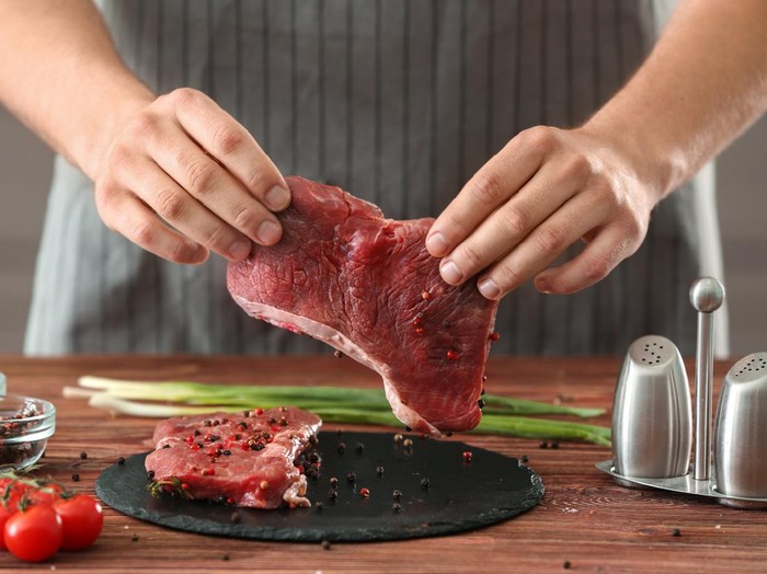 Man preparing meat in kitchen