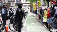 Masa aksi dijaga ketat oleh pihak kepolisian agar tidak berlangsung terlalu lama di tengah pandemi COVID-19. Foto AP/Nam Y. Huh.