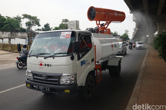Petugas PMI dengan menggunakan truck dan spray gunner melakukan penyemprotan disinfektan di Jalan Raya Kalimalang, Jakarta Timur, Selasa (19/5/2020).