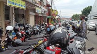 Mereka memarkir motor berdesakan di perbatasan jalan yang ditutup. Kemudian, mereka ramai-ramai berjalan ke kawasan kota untuk berburu barang yang diinginkan.