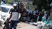 Seorang pedagang menyelamatkan barang dagangannya.