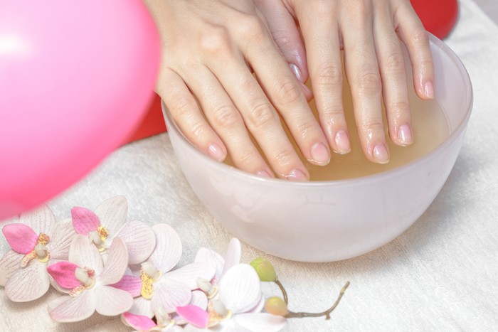 Hands care in the spa. Beautiful womans hands with perfect manicure. Manicurist master makes manicure