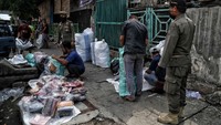 Petugas Satpol PP memantau saat para pedagang mengemas barang mereka.  