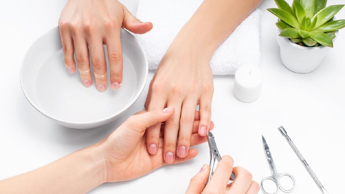 perawatan tangan Hands care in the spa. Beautiful womans hands with perfect manicure. Manicurist master makes manicure