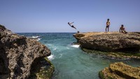 Seorang pemuda Libanon melompat ke Laut Mediterania dari corniche, di Beirut, Libanon, Senin, 18 Mei 2020.