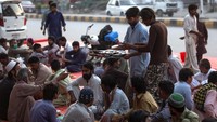Relawan membagikan menu berbuka puasa di Islamabad, Pakistan, Selasa (19/5).  