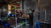 Pemasangan pembatas plastik di setiap meja ini untuk mencegah penyebaran virus Corona.