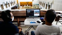 Petugas memantau jalannya misa dari laptop.