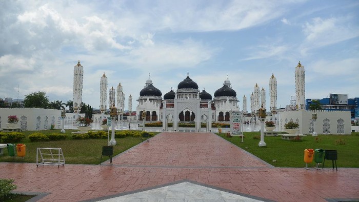 Seorang warga berjalan di halaman Masjid Raya Baiturrahman, Banda Aceh, Minggu (5/4/2020). Objek wisata religi Masjid Raya Baiturrahman yang juga merupakan salah situs sejarah itu sepi pengunjung pada hari libur dampak dari pandemi Corona Virus (COVID-19). ANTARA FOTO/Ampelsa/foc.