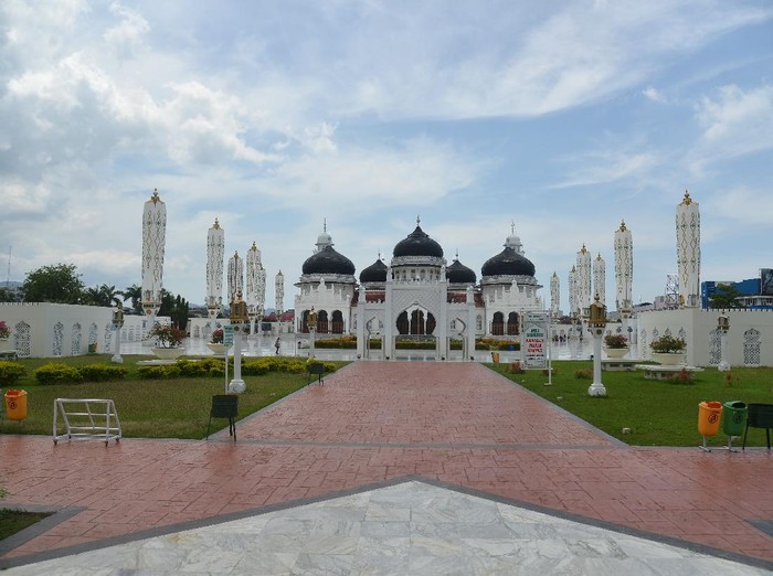 Seorang warga berjalan di halaman Masjid Raya Baiturrahman, Banda Aceh, Minggu (5/4/2020). Objek wisata religi Masjid Raya Baiturrahman yang juga merupakan salah situs sejarah itu sepi pengunjung pada hari libur dampak dari pandemi Corona Virus (COVID-19). ANTARA FOTO/Ampelsa/foc.
