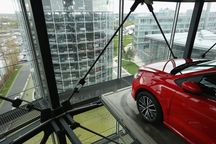 Glass Car Silo WOLFSBURG, GERMANY - DECEMBER 04: A Volkswagen t-roc is presented in one of the twin car towers at the Volkswagen Autostadt visitors center on December 4, 2018 in Wolfsburg, Germany. Volkswagen, Germany's biggest carmaker, has been embroiled in a costly emissions scandal after it installed illegal software in millions of its cars. The car giant announced recently that the company will face a difficult year in 2019 due to ongoing court cases stemming from the software, designed to manipulate emissions in diesel cars, which has so far cost the company EUR 28 billion in fines and costs. (Photo by Carsten Koall/Getty Images)