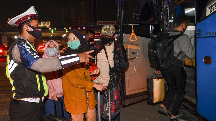 Calon pemudik yang terjaring razia penyekatan berjalan menaiki bus yang akan membawa mereka ke Terminal Pulogebang, Jakarta, di Pintu Tol Cikarang Barat, Bekasi, Jawa Barat, Kamis (21/5/2020). Calon pemudik yang terjaring razia penyekatan oleh Polda Metro Jaya tersebut dibawa ke terminal Pulogebang untuk kemudian diarahkan kembali menuju Jakarta. ANTARA FOTO/Nova Wahyudi/aww.