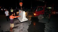 Pekerja menggunakan alat berat untuk mengangkat beton saat pembukaan akses di Jalan Sultan Agung, Tegal, Jawa Tengah, Kamis (14/5/2020).