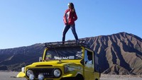 Ini pose saat Tante Ernie berwisata di Gunung Bromo. Kali ini, tante Ernie berdiri di atas mobil 4x4 yang biasa ditemukan di situs wisata tersebut. Foto: Instagram @himynameisernie
