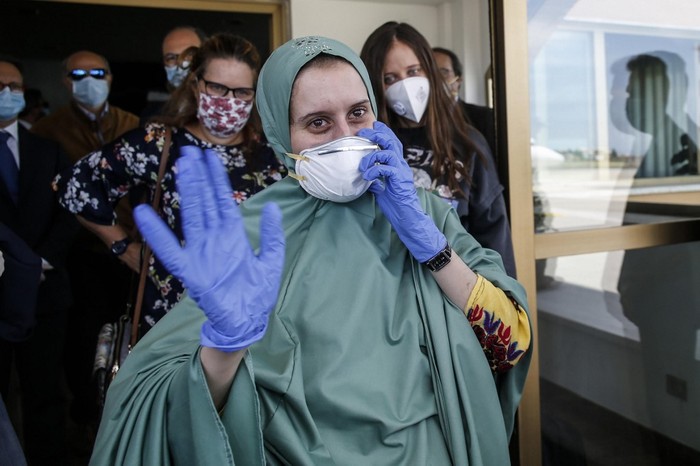 Italian volunteer aid worker Silvia Costanza Romano (R), who was kidnapped in Kenya in late 2018, wearing a khimar and face mask, embraces her mother Francesca upon her arrival at Romes military Ciampino airport on May 11, 2020, following her release. - Silvia Romano was 23 and working as a volunteer in the orphanage in Chakama village in southeast Kenya when she was seized by gunmen in November 2018. (Photo by FABIO FRUSTACI / ANSA / AFP) / Italy OUT / ITALY OUT