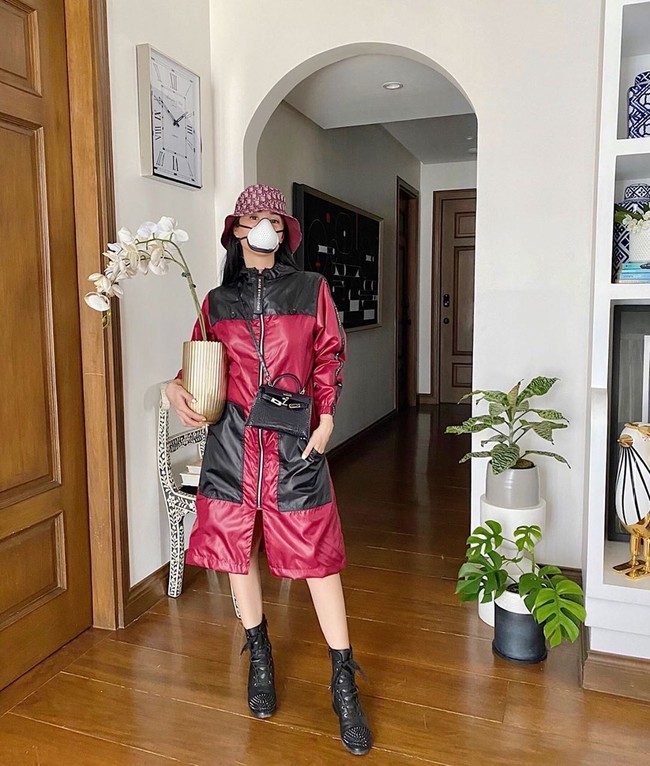 Tampil edgy, kolektor tas branded ini mengenakan baju APD warna marun-hitam rancangan desainer Mark Bumgarner. Tak lupa masker berdesain futuristik, tas Hermes Kelly berukuran mikro dan bucket hat dari Dior. Foto: Instagram/@iamhearte