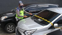 Polisi memasang garis polisi pada mobil travel ilegal yang ditahan di pos pemeriksaan Pembatasan Sosial Berskala besar (PSBB) Balearjosari, Malang, Jawa Timur, Jumat (22/5/2020).