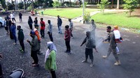 Pemudik yang baru tiba disemprot cairan disinfektan di tempat Screening pemudik GOR Tawangalun, Banyuwangi, Jawa Timur, Jumat (22/5/2020).