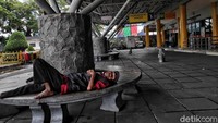 Seorang warga tidur di pelabuhan yang sepi.