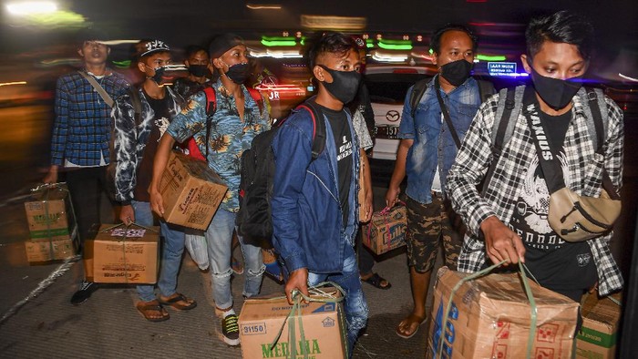 Calon pemudik yang terjaring razia penyekatan berjalan menaiki bus yang akan membawa mereka ke Terminal Pulogebang, Jakarta, di Pintu Tol Cikarang Barat, Bekasi, Jawa Barat, Kamis (21/5/2020). Calon pemudik yang terjaring razia penyekatan oleh Polda Metro Jaya tersebut dibawa ke terminal Pulogebang untuk kemudian diarahkan kembali menuju Jakarta. ANTARA FOTO/Nova Wahyudi/aww.