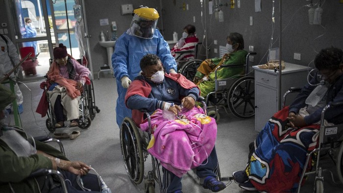 Seorang dokter di Peru mendorong seorang pasien virus Corona yang duduk di kursi roda A doctor pushes a COVID-19 patient in a wheelchair in the emergency area of the Guillermo Almenara hospital in Lima, Peru, Friday, May 22, 2020. Despite strict measures to control the virus, this South American nation of 32 million has become one of the countries worst hit by the disease. (AP Photo/Rodrigo Abd)