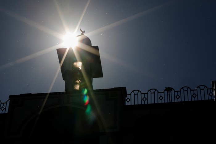 The sun shines behind the Omar Mosque in Berlins Kreuzberg district just hours before the start of the Muslim holy fasting month of Ramadan on April 23, 2020. (Photo by David GANNON / AFP)