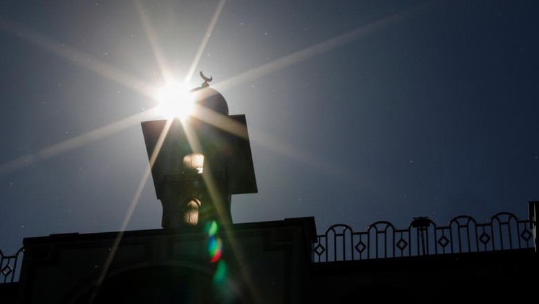 The sun shines behind the Omar Mosque in Berlins Kreuzberg district just hours before the start of the Muslim holy fasting month of Ramadan on April 23, 2020. (Photo by David GANNON / AFP)