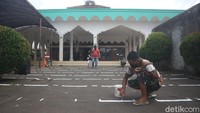 Pengusurus masjid terlihat mengecat halaman untuk membatasi jarak guna menggelar Salat Id besok, Minggu (24/5/2020).