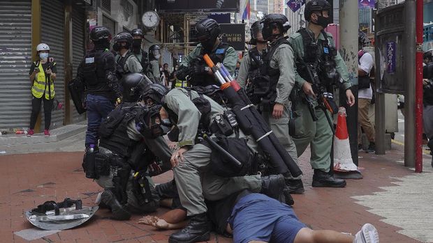 Riot police detain a protester during a demonstration against Beijing's national security legislation in Causeway Bay in Hong Kong, Sunday, May 24, 2020. Hong Kong police fired volleys of tear gas in a popular shopping district as hundreds took to the streets Sunday to march against China's proposed tough national security legislation for the city. (AP Photo/Vincent Yu)