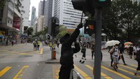 Seorang demonstran memukul lampu pengatur lalu lintas saat ikut serta dalam aksi protes yang digelar di kawasan Hong Kong, Minggu (24/5/2020). AP Photo/Kin Cheung.