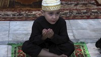 Seorang anak di Pakistan tampak ikut serta melaksanakan salat Idul Fitri bersama keluarga di kawasan Peshawar, Pakistan, Minggu (24/5/2020). AP Photo/Muhammad Sajjad.