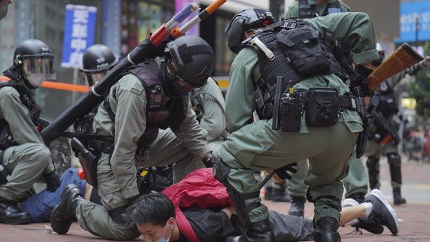 Riot police detain a protester during a demonstration against Beijing's national security legislation in Causeway Bay in Hong Kong, Sunday, May 24, 2020. Hong Kong police fired volleys of tear gas in a popular shopping district as hundreds took to the streets Sunday to march against China's proposed tough national security legislation for the city. (AP Photo/Vincent Yu)