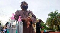 Seorang pria membersihkan tangannya, sebagai tindakan pencegahan terhadap COVID-19, sebelum memasuki masjid di provinsi Pattani, Thailand (Surapan Boonthanom/Reuters)