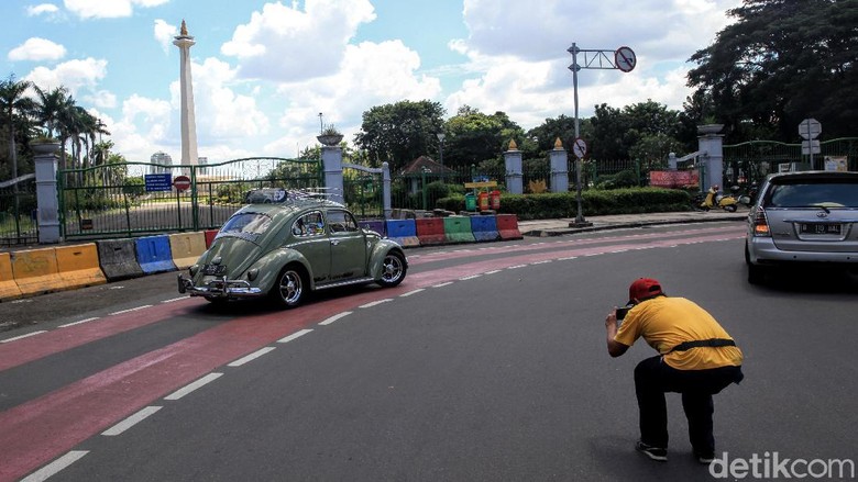 Monas Tutup, Pengunjung Cuma Foto-foto dari Balik Pagar Pengunjung berfoto Dari balik Pagar Monumen Nasional, Jakarta, Senin (25/5/2020). PSBB Corona membuat tempat wisata ditutup untuk umum.
