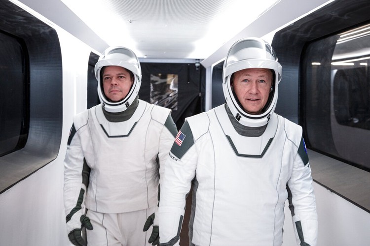 In this Jan. 17, 2020 photo made available by SpaceX, NASA astronauts Bob Behnken, left, and Doug Hurley, wearing SpaceX spacesuits, walk through the Crew Access Arm connecting the launch tower to the SpaceX Crew Dragon spacecraft during a dress rehearsal at NASAs Kennedy Space Center in Cape Canaveral, Fla. For their May 27, 2020 mission, Hurley will be in charge of launch and landing and Behnken will oversee rendezvous and docking at the International Space Station. (SpaceX via AP)