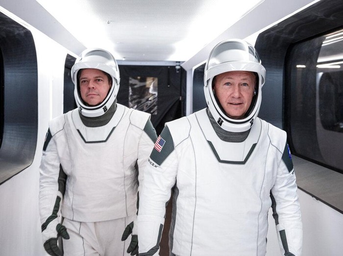 In this Jan. 17, 2020 photo made available by SpaceX, NASA astronauts Bob Behnken, left, and Doug Hurley, wearing SpaceX spacesuits, walk through the Crew Access Arm connecting the launch tower to the SpaceX Crew Dragon spacecraft during a dress rehearsal at NASAs Kennedy Space Center in Cape Canaveral, Fla. For their May 27, 2020 mission, Hurley will be in charge of launch and landing and Behnken will oversee rendezvous and docking at the International Space Station. (SpaceX via AP)