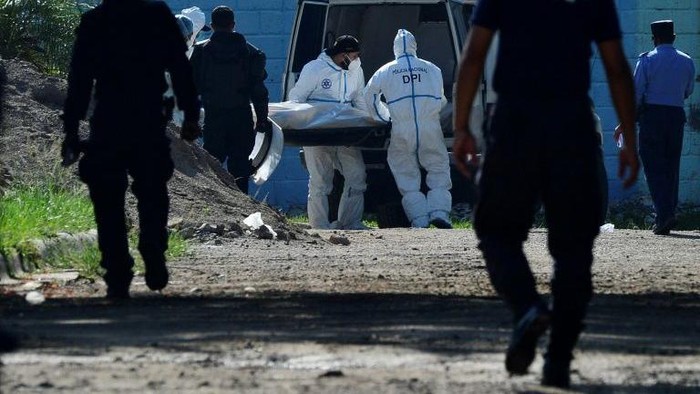Tim forensik membawa mayat tahanan yang dibunuh oleh orang yang diduga anggota geng di penjara Honduras (AFP Photo/Orlando Sierra)